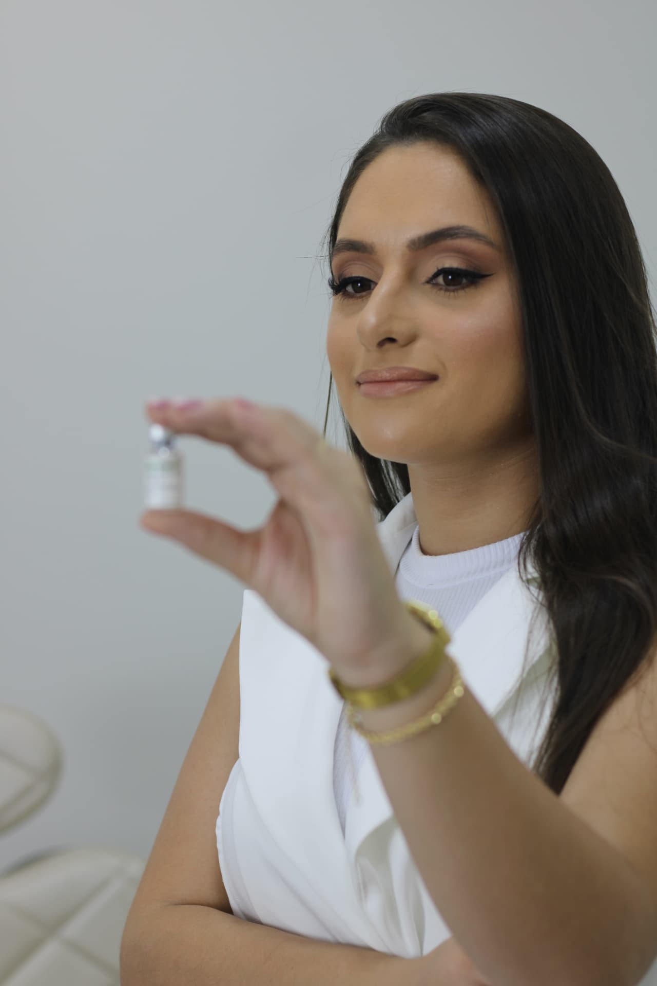 Dra. Bruna Reichardt segurando um frasco de toxina botulínica em sua clínica em Curitiba